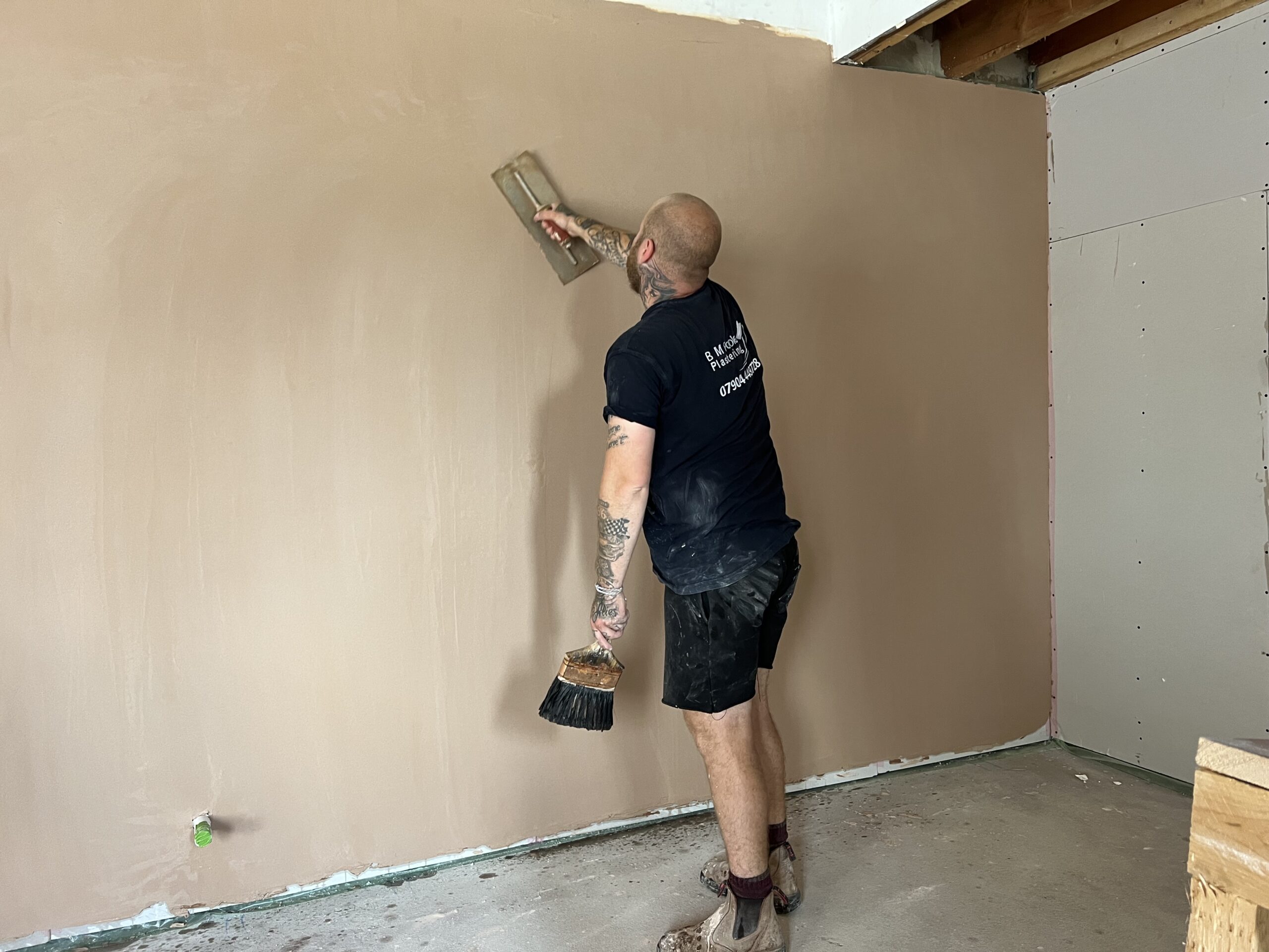 plasterer skimming a plasterboard wall in a house renovation in shropshire